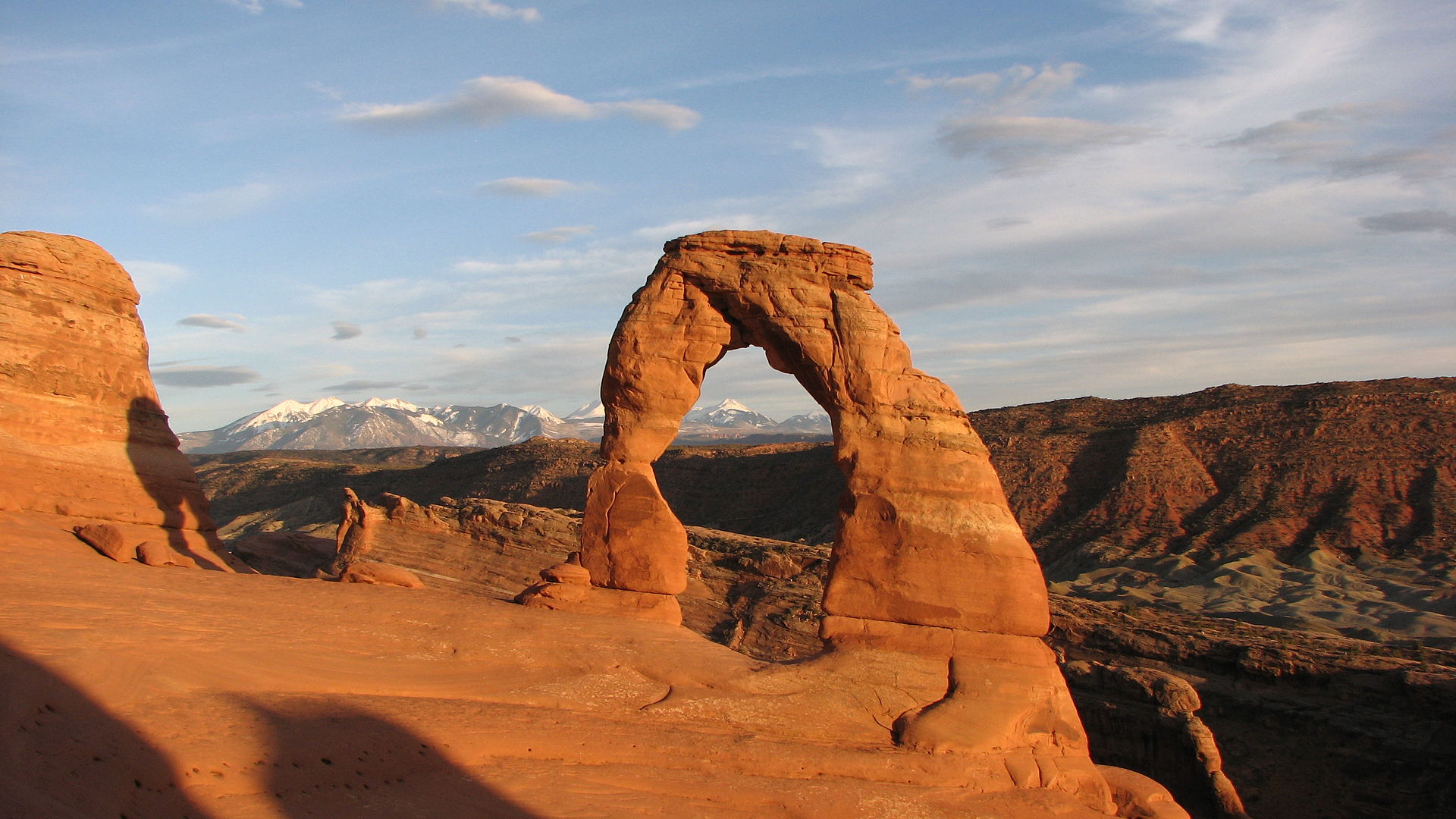 Delicate Arch in Arches National Park bij avondlicht, met de La Sal Mountains op de achtergrond